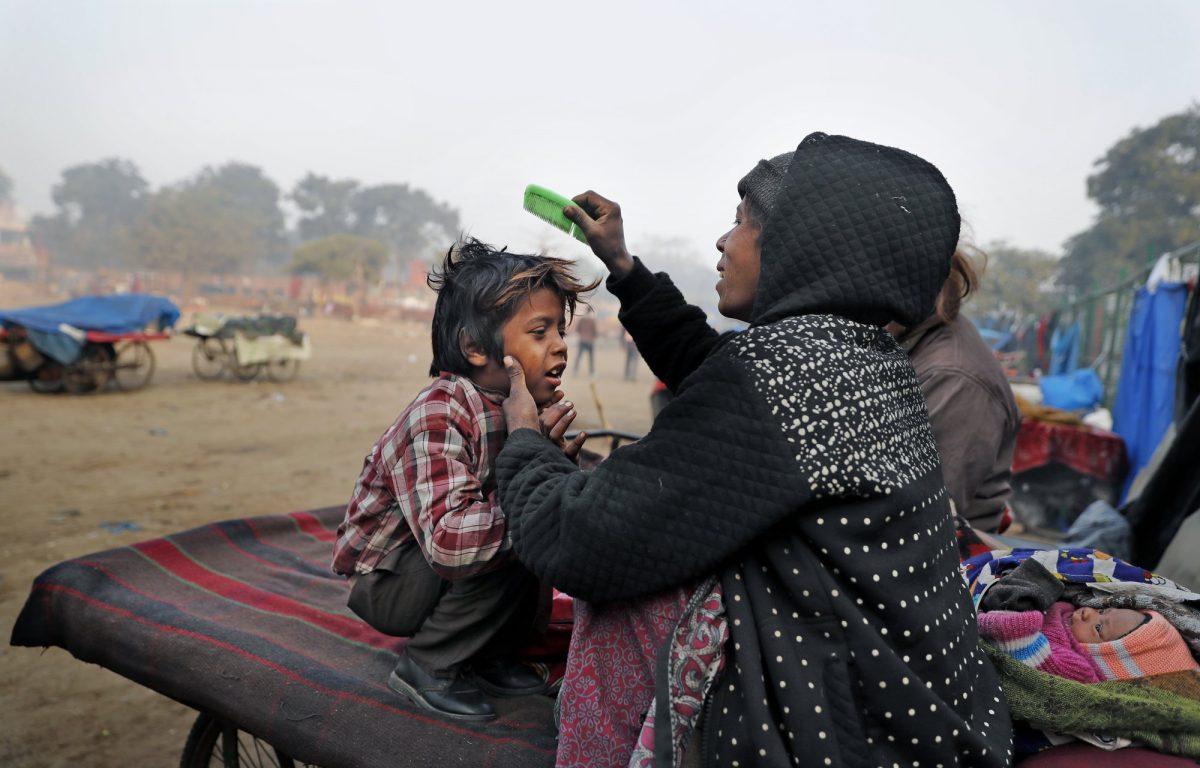 In this, photo, Ruby Khan helps her 7-year-old son Farmaan get ready for school in New Delhi, India, on Jan. 18, 2019. (Altaf Qadri/AP Photo)