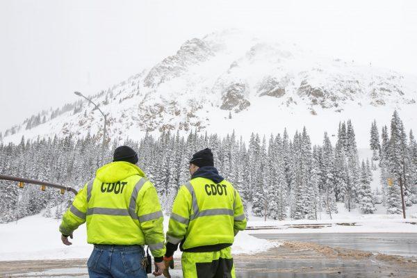 Colorado Department of Transportation officials discuss with each other near Interstate 70 during a snowstorm, on March 7, 2019. (Hugh Carey/Summit Daily News via AP)