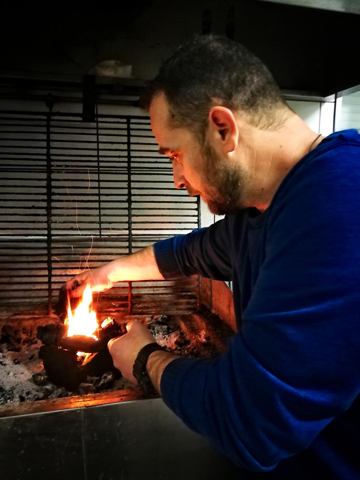 Chef Grigoris Koudounas prepares the coals to cook an amazing feast. (Phil Butler)