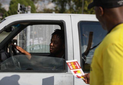A firefighter encourages a passing driver to vote on a proposition that would raise firefighter wages near the Kashmere Multi-Service Center polling place in Houston on Nov. 6, 2018. (Loren Elliott/Getty Images)
