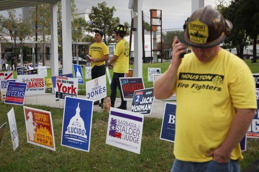 Firefighters encourage voters to vote on a proposition that would raise their pay outside the Metropolitan Multi-Service Center polling place in Houston on Nov. 6, 2018. (Loren Elliott/Getty Images)