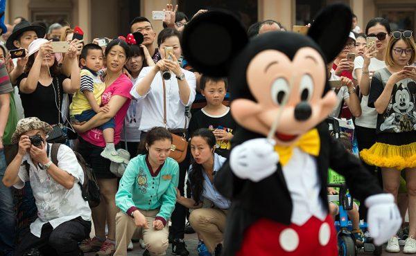 People take pictures of Mickey Mouse (in foreground) after the opening ceremony of the Shanghai Disney Resort in Shanghai on June 16, 2016.<br/>(Johannes Eisele/AFP/Getty Images)