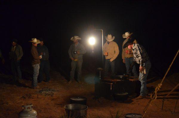 Before the morning light breaks, cowboys gather around the wood stove for coffee and warmth. (Shannon Keller Rollins)