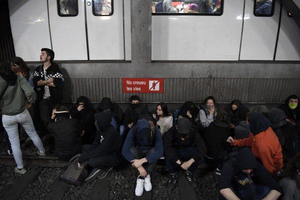 Protesters sit on the railroad tracks after occupying a train station in Barcelona during a strike day against the trial of former Catalan separatist leaders held in Madrid, on Feb. 21, 2019. (Louis Gene/AFP/Getty Images)