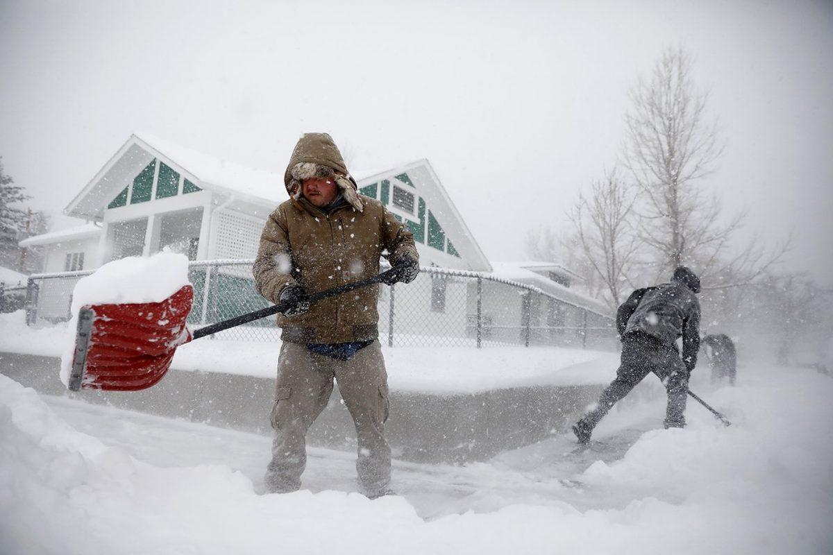Martin Thompson clears snow from the sidewalk on March 13, 2019, during a winter storm in Casper, Wyo. (Josh Galemore/The Casper Star-Tribune via AP)
