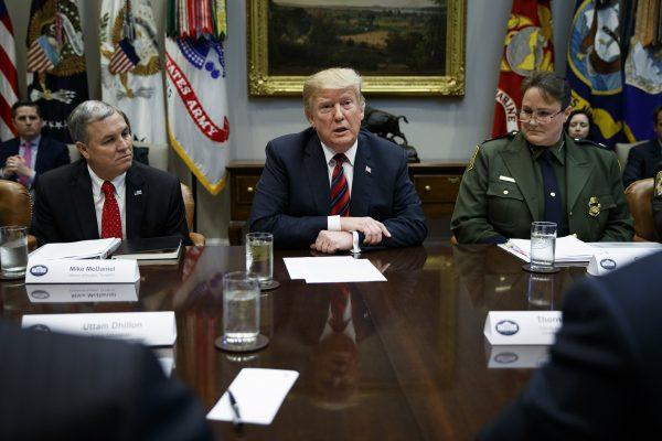 Mike McDaniel, director of Houston High Intensity Drug Trafficking Areas, left, and Carla Provost, chief of the U.S. Border Patrol, right, listen as President Donald Trump speaks in the Roosevelt Room of the White House on March 13, 2019. (Evan Vucci/AP Photo)