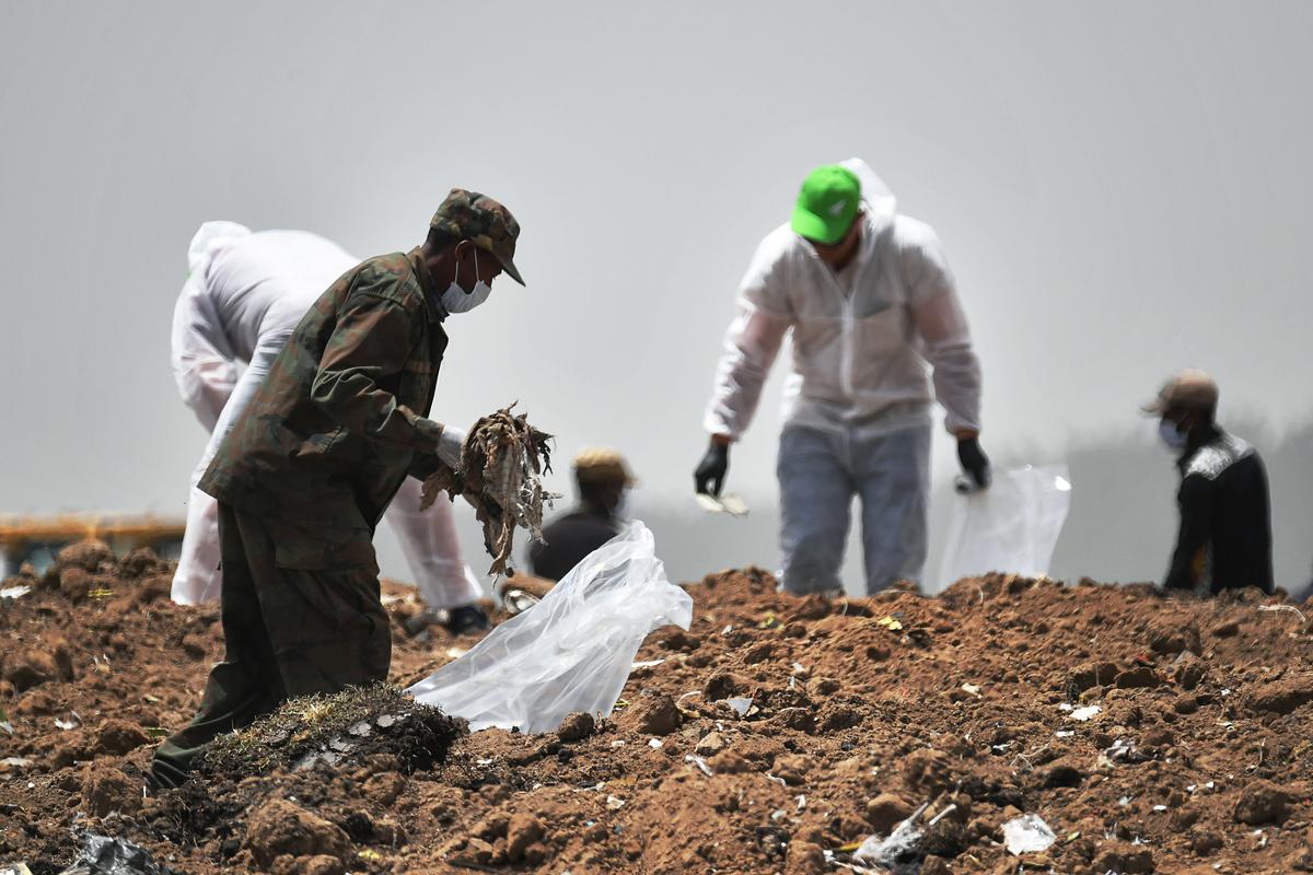 Forensics experts comb through the dirt for debris at the crash site of the Ethiopian Airlines operated Boeing 737 MAX aircraft, at Hama Quntushele village in Oromia region, on March 14, 2019, four days after the plane crashed into a field killing 157 passengers and crew. (Tony Karumba/AFP/Getty Images)