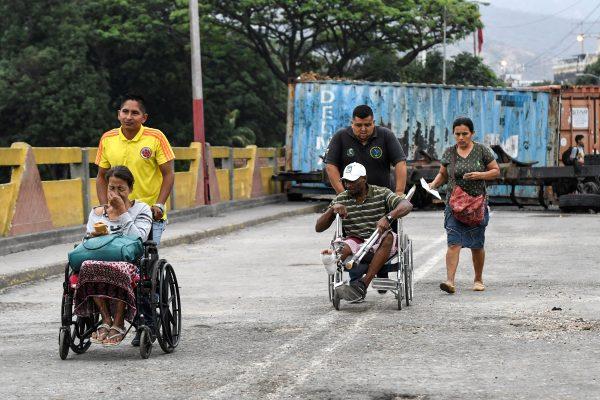 People are wheeled across the Simon Bolivar International Bridge from San Antonio del Tachira, Venezuela to Cucuta, Colombia, on March 11, 2019, after Venezuelan authorities opened a humanitarian corridor for the passage of students and patients to Colombia. (Juan Pablo Bayona/AFP/Getty Images)
