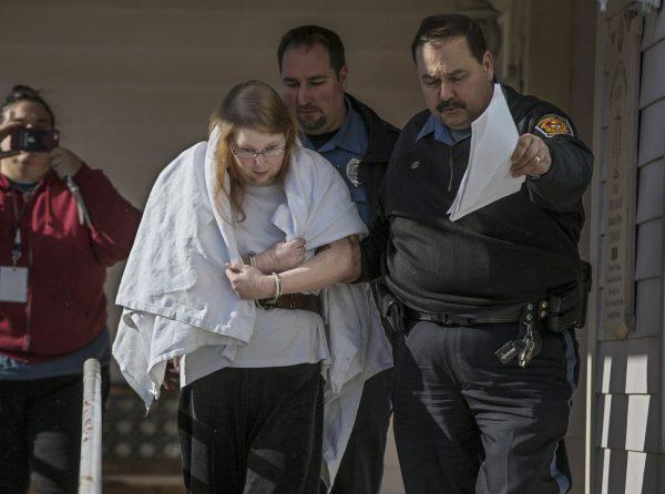 Sara Packer, center, handcuffed, the adoptive mother of Grace Packer, is led out of District Court in Newtown, Pa., by Pennsylvania Constables and taken into custody on Jan. 8, 2017. (Michael Bryant/The Philadelphia Inquirer/File via AP)