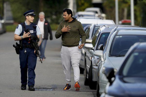 Ash Mohammed, right, talks to a police officer about his father and two brothers who are missing near the Masjid Al Noor mosque, site of one of the mass shootings at two mosques in Christchurch, New Zealand, on March 16, 2019. (Mark Baker/AP Photo)