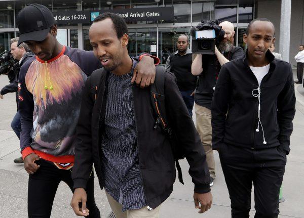 Abdifatah Ibrahim (C) and his brother Abdi (R), walk with an unidentified friend in Christchurch, New Zealand, on March 17, 2019. Abdifatah and Abdi are the older brothers of 3-year-old Mucaad, who is the youngest known victim of the mass shooting in Christchurch, New Zealand on March 15, 2019. (Mark Baker via AP)