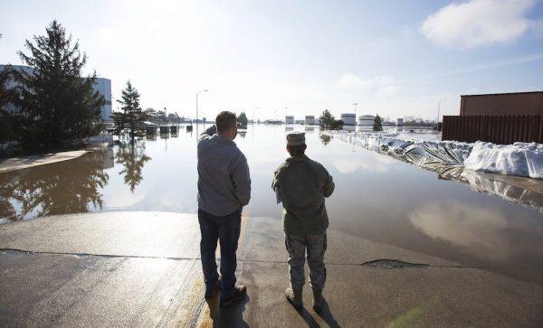Luke Thomas and Air Force Tech Sgt. Vanessa Vidaurre look at a flooded portion of Offutt Air Force Base on March 17, 2015, in Bellevue, Neb. (Z Long/Omaha World-Herald via AP)