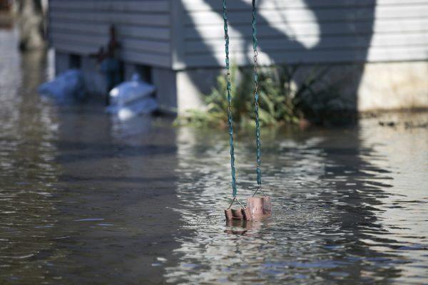 A swing hung from a tree dips into flood waters on Shore Drive on March 16, 2019, in Machesney Park, Ill. Many rivers and creeks in the Midwest are at record levels after days of snow and rain. (Scott P. Yates/Rockford Register Star via AP)