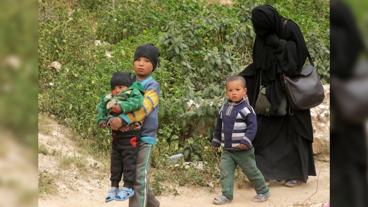 Woman and children of ISIS terrorists walk as they surrendered in the village of Baghouz, Deir Al Zor province, Syria, on March 14, 2019. (Issam Abdallah/Reuters)