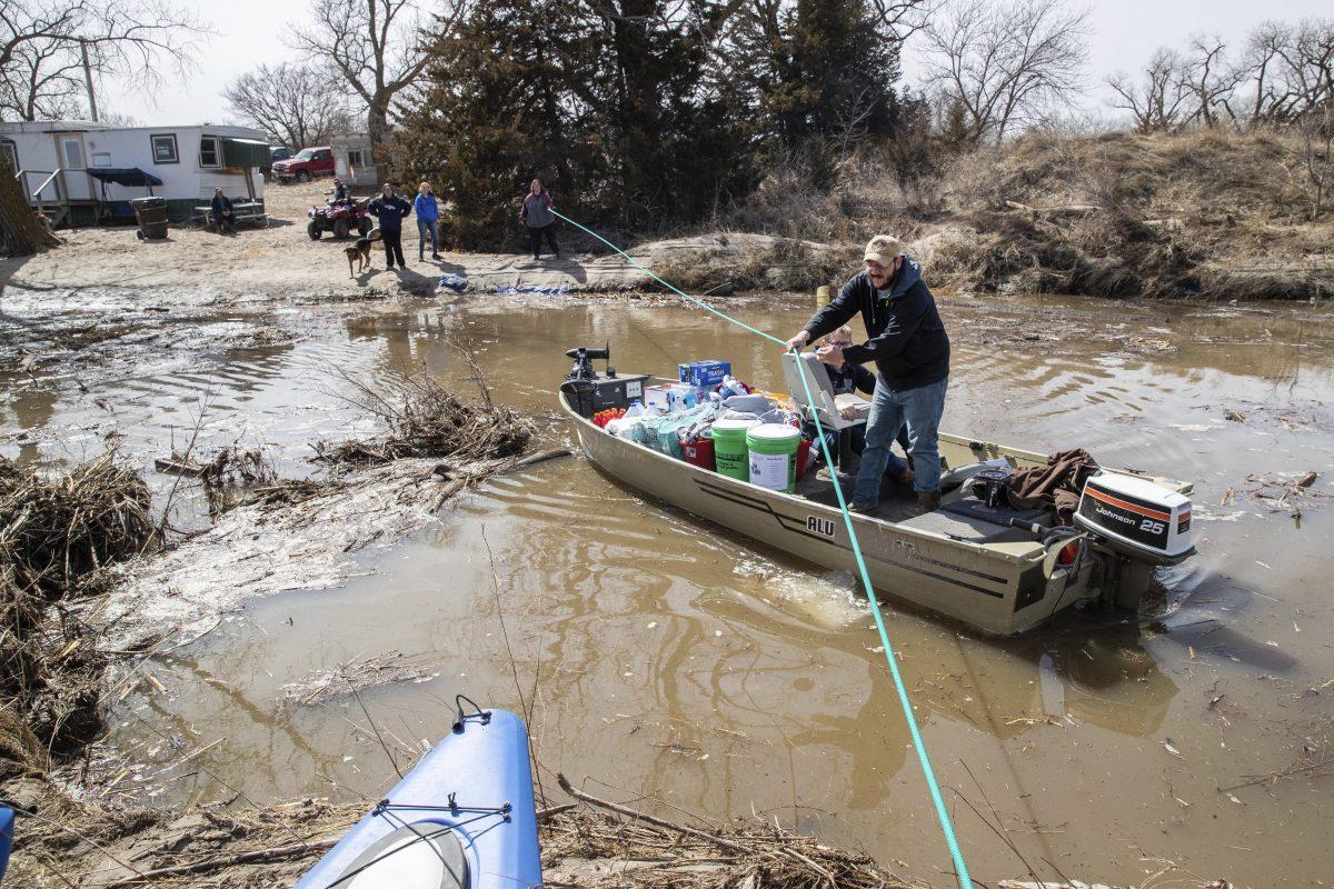 Boat brings supplies to the Bellwood Lakes area, Bellwood, Neb., on March 18, 2019. (Bredan Sullivan/Omaha World-Herald/AP)