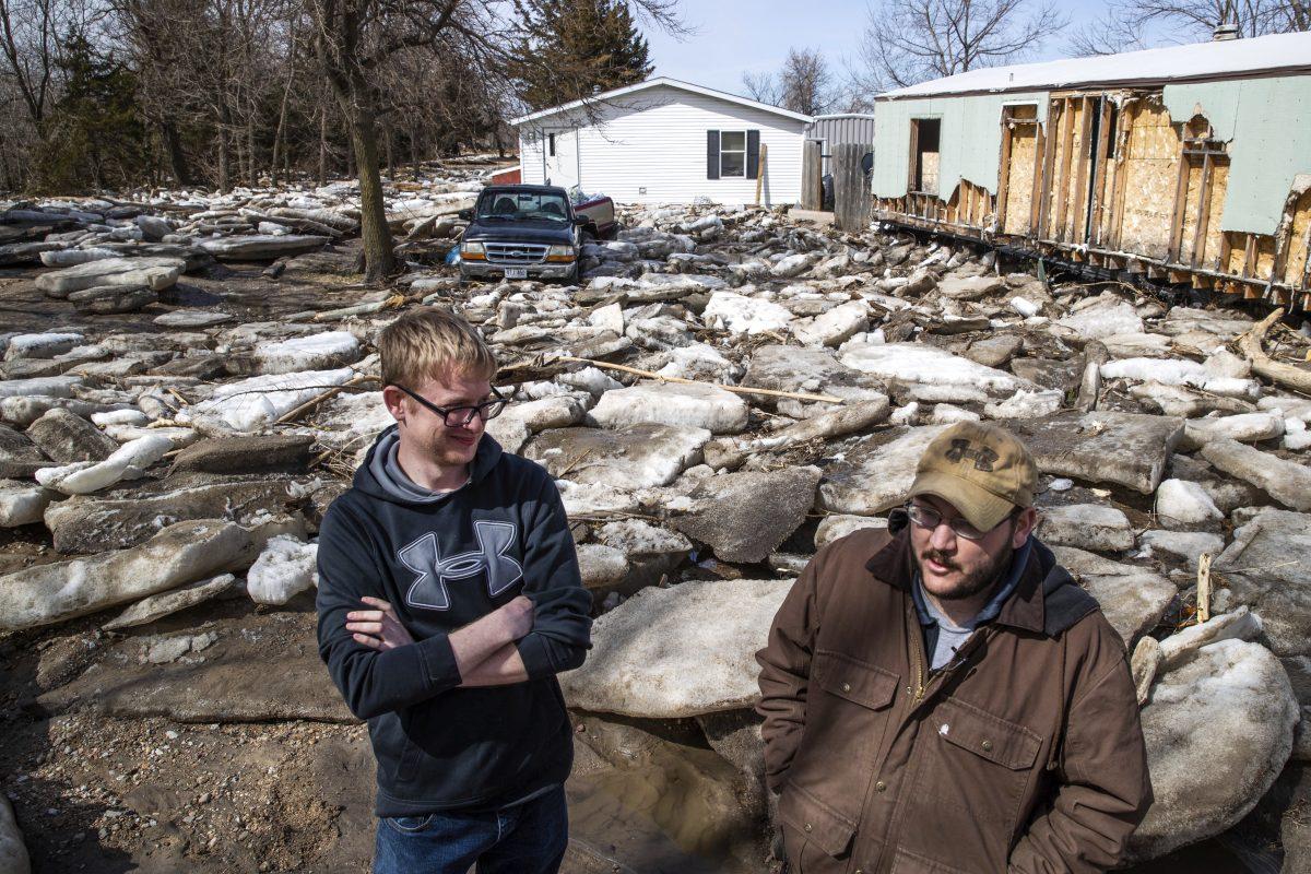 Residents stand in the Bellwood Lakes neighborhood, much of the area was heavily impacted by flooding along the Platte River Bellwood, Neb., on March 18, 2019. (Brendan Sullivan/The World-Herald/AP)
