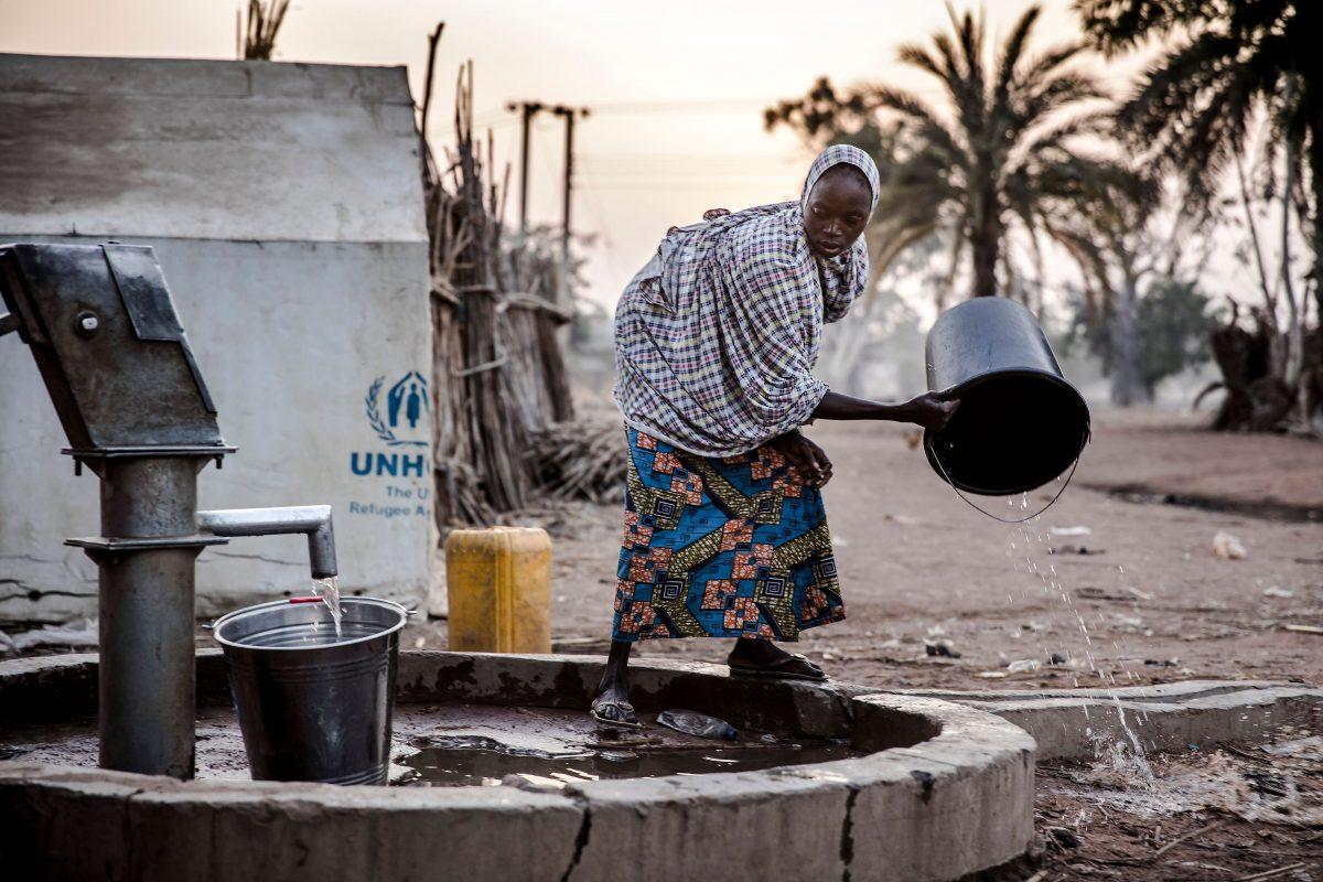 A woman pours water from a well at Malkohi refugee camp in Jimeta, Adamawa State, Nigeria on Feb. 19, 2019. (LUIS TATO/AFP/Getty Images)