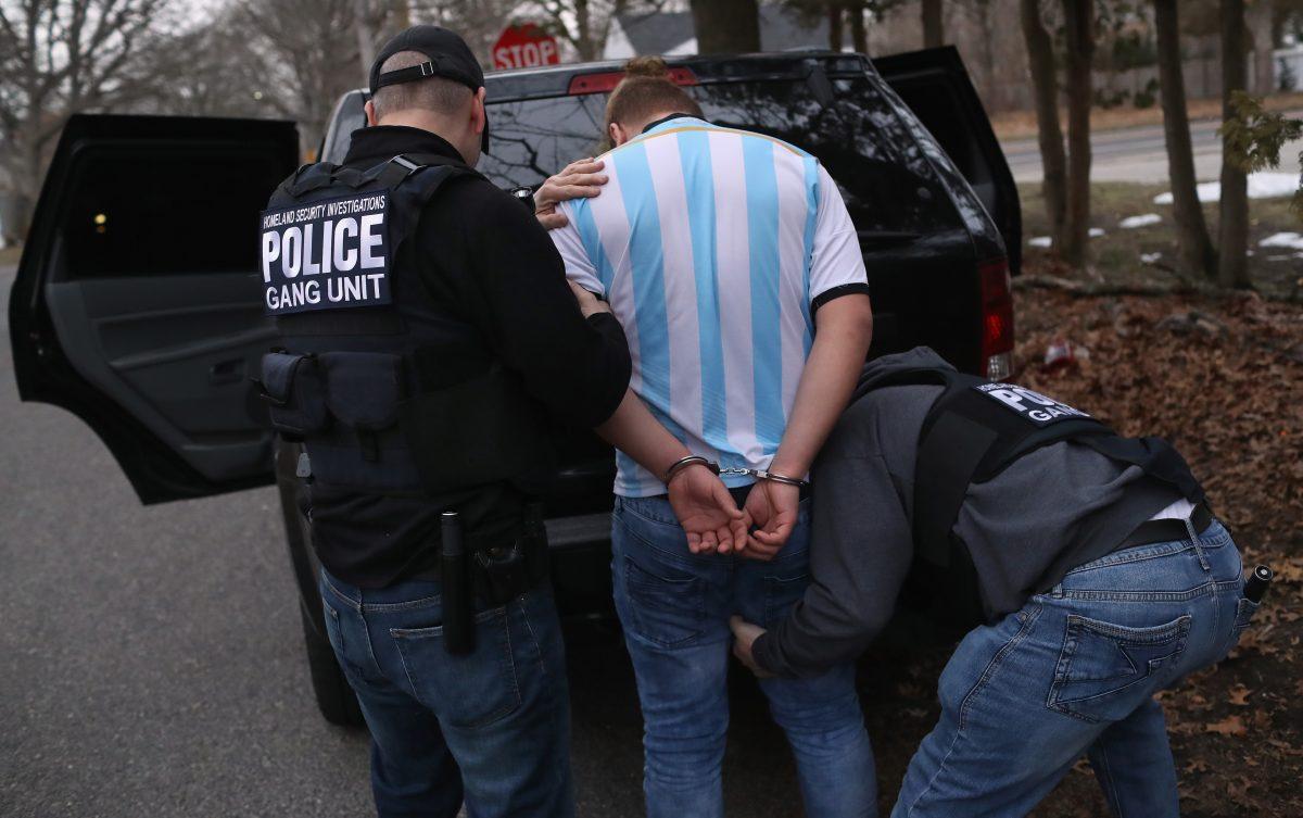 Homeland Security Investigations (HSI) ICE agents frisk a suspected MS-13 gang member and Honduran immigrant after arresting him at his home in Brentwood, N.Y., on March 29, 2018. (John Moore/Getty Images)