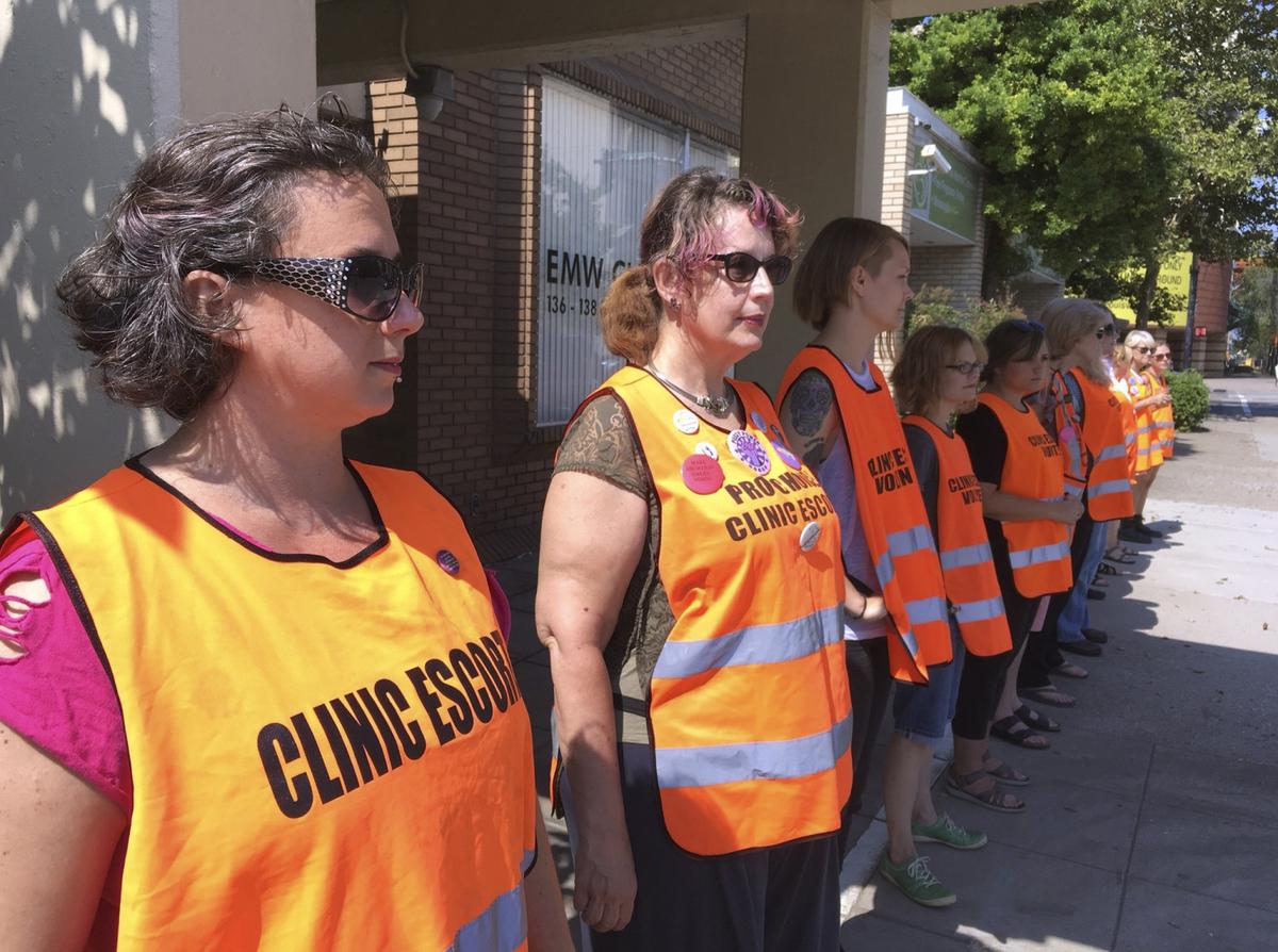 In this July 17, 2017 file photo, escort volunteers line up outside the EMW Women's Surgical Center in Louisville, Ky. (AP Photo/Dylan Lovan, File)
