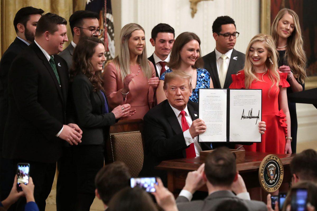 President Donald Trump holds up an executive order he signed protecting freedom of speech on college campuses during a ceremony in the East Room at the White House March 21, 2019 in Washington. (Chip Somodevilla/Getty Images)