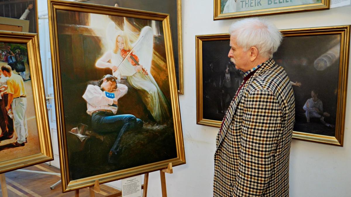 A man observes a painting of a sleeping woman with an angel at the Zhen Shan Ren Art Exhibition in Kiev, Ukraine. (NTD/screenshot)