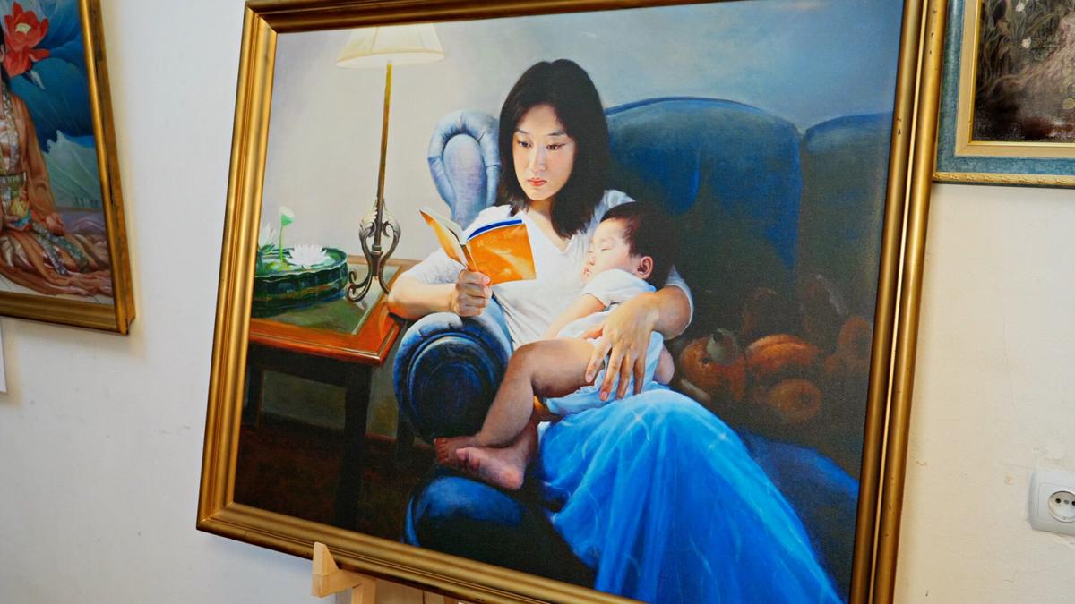 A painting of a woman holding a child and reading Zhuan Falun from the Zhen Shan Ren Art Exhibition. (NTD/screenshot)