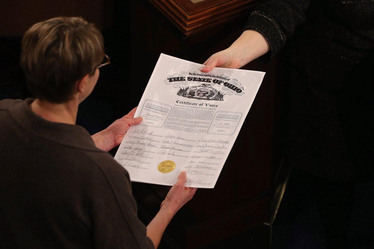 Congressional clerks pass the Electoral College certificate from the state of Ohio while unsealing and organizing all the votes from the 50 states in the House of Representatives chamber at the U.S. Capitol in Washington on Jan. 4, 2013. (Chip Somodevilla/Getty Images)