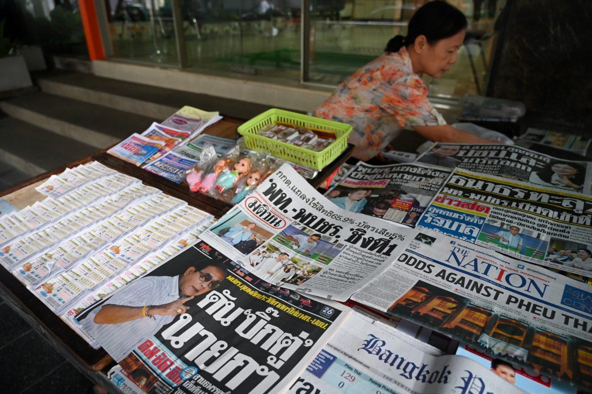 A vendor arranges newspapers at her newsstand in Bangkok, Thailand, on March 25, 2019, a day after Thailand's general election. (Ye Aung Thu/AFP/Getty Images)