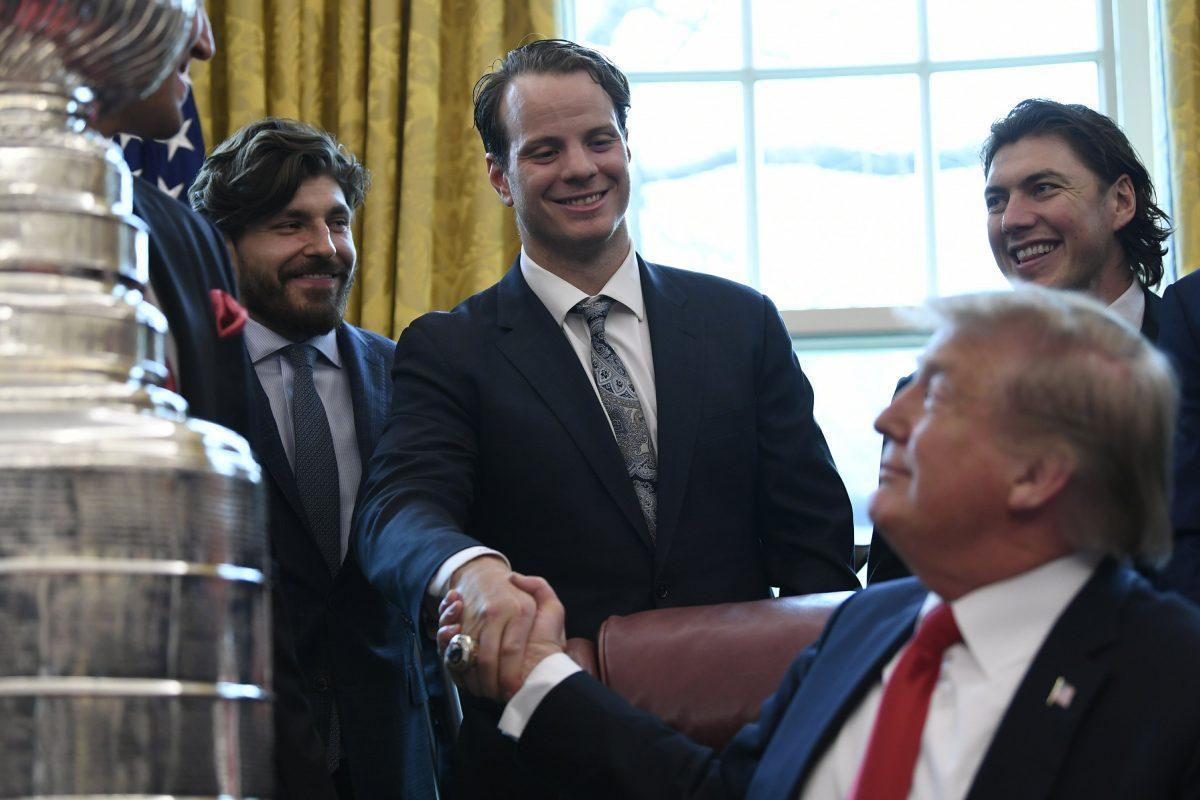 President Donald Trump, front right, shakes hands with John Carlson of the 2018 Stanley Cup Champion Washington Capitals hockey team in the Oval Office of the White House in Washington, Monday, March 25, 2019. Teammate T.J. Oshie watches at right. (Susan Walsh/AP Photo)