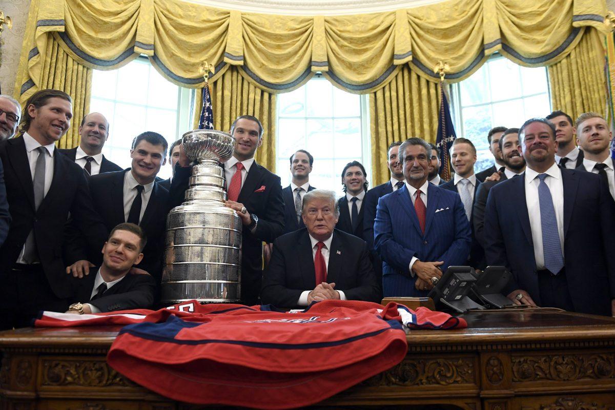 President Donald Trump, center, poses for a photo as he hosts the 2018 Stanley Cup Champion Washington Capitals hockey team in the Oval Office of the White House in Washington, Monday, March 25, 2019. (Susan Walsh/AP Photo)