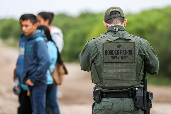 A Border Patrol agent apprehends illegal aliens who have just crossed the Rio Grande from Mexico into Penitas, Texas, on March 21, 2019. (Charlotte Cuthbertson/The Epoch Times)