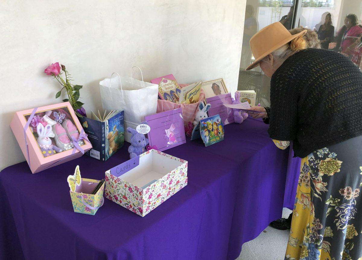 A woman looks a display of mementos at the funeral service for Trinity Love Jones, the 9-year-old whose body was found this month stuffed in a duffel bag along an equestrian trail, at St. John Vianney Catholic Church in Hacienda Heights, Calif., on March 25, 2019. (John Rogers/AP Photo)
