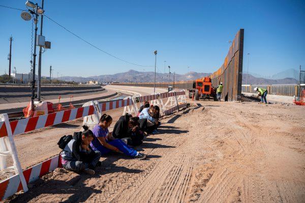 Salvadoran migrants wait for transport to arrive after turning themselves into U.S. Border Patrol by a border fence under construction in El Paso, Texas, on March 19, 2019. (Paul Retje/AFP/Getty Images)