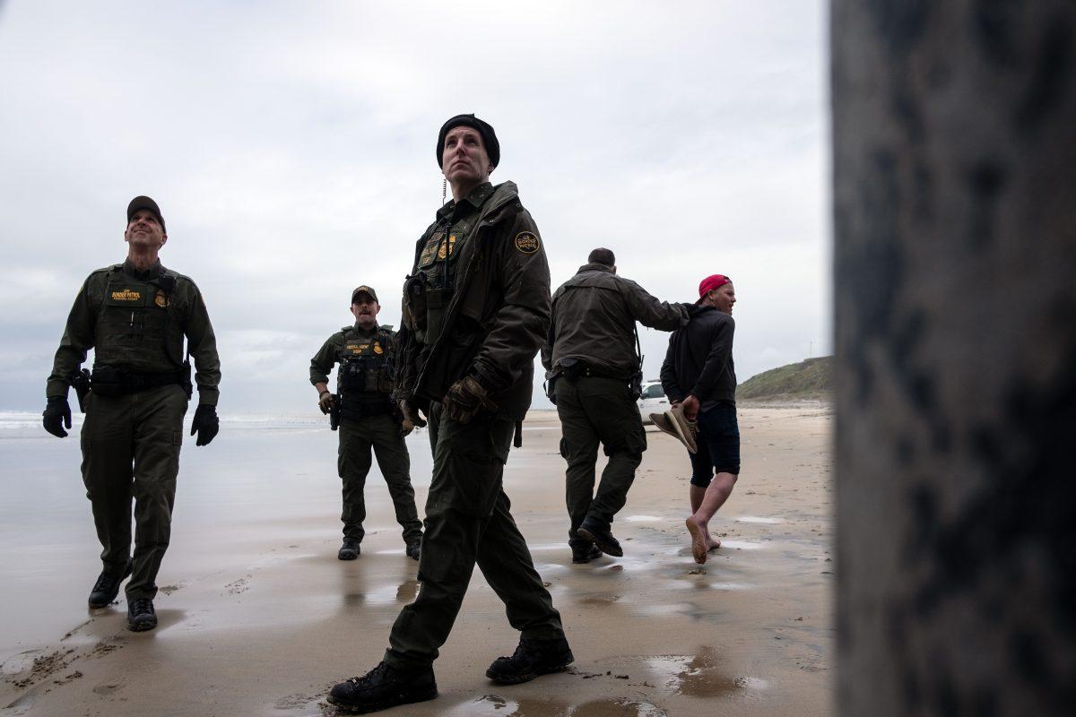 A Central American migrant is taken in custody by Border Patrol after crossing the U.S.–Mexico border fence from Tijuana to San Diego as seen from Playas de Tijuana, Mexico, on March 21, 2019. (Guillermo Arias/AFP/Getty Images)