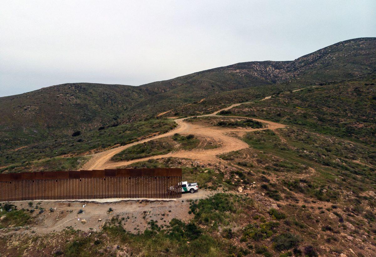 Aerial view a Border Patrol truck sits next to a section of the U.S.–Mexico border fence as it ends–Mexico on the left side and the United States on the right–at El Nido de las Aguilas, Tijuana, Mexico, on March 26, 2019. (Guillermo Arias/AFP/Getty Images)