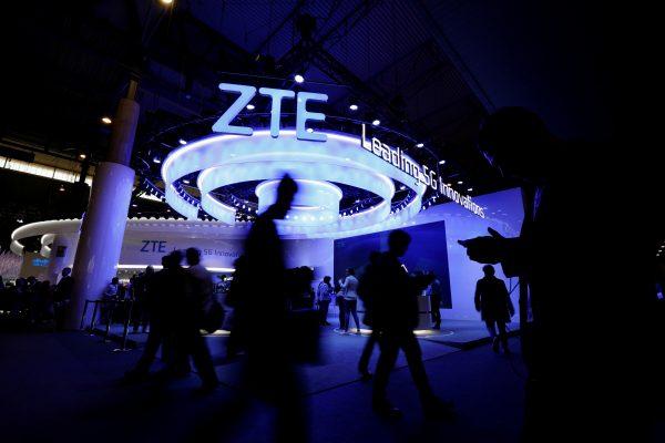 People walk next to a ZTE booth at the Mobile World Congress in Barcelona, Spain on Feb. 25, 2019. (Rafael Marchante/Reuters)