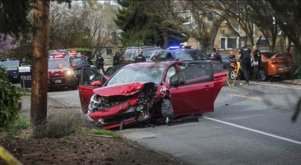 Police work the scene where two cars collided in Seattle, on March 27, 2019, after a gunman opened fire on vehicles in a Seattle neighborhood. (Steve Ringman/The Seattle Times via AP)