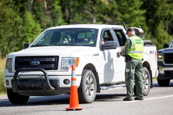 A U.S. Border Patrol agent checks identification of a driver at a highway checkpoint in West Enfield, Maine, on Aug. 1, 2018. (Scott Eisen/Getty Images)