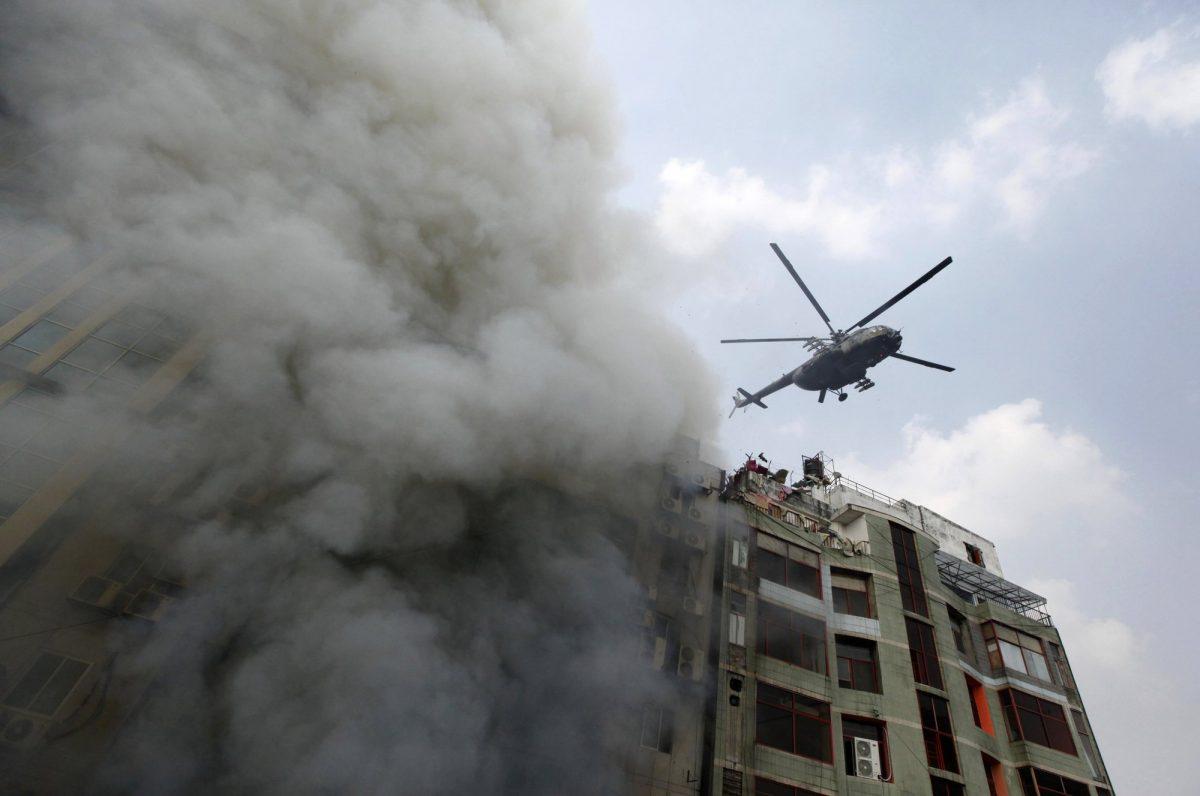 Firefighters evacuate an injured after a multi-storied office building caught fire in Dhaka, Bangladesh, on March 28, 2019. (Mahmud Hossain Opu/AP Photo)