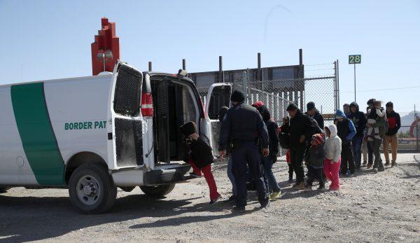 A Border Patrol agent loads detained migrants into a van at the border of the United States and Mexico in El Paso, Tex., on March 31, 2019. (Justin Sullivan/Getty Images)