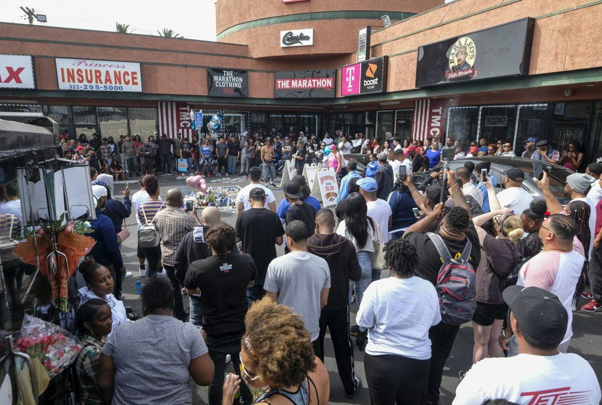 Fans of rapper Nipsey Hussle gather at a makeshift memorial in the parking lot of the Marathon Clothing store in Los Angeles, on April 1, 2019. (Ringo H.W. Chiu/AP Photo)