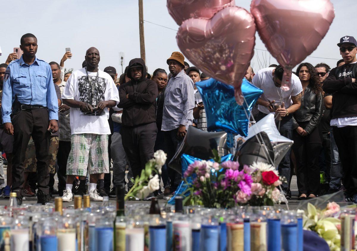 Fans of rapper Nipsey Hussle appear at a makeshift memorial in the parking lot of Hussle’s Marathon Clothing store in Los Angeles, on April 1, 2019. (Ringo H.W. Chiu/AP Photo)