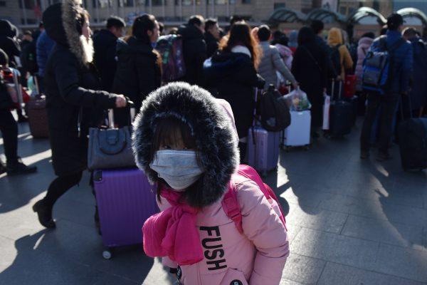 A girl waits outside a railway station in Beijing. (Greg Baker/AFP/Getty Images)
