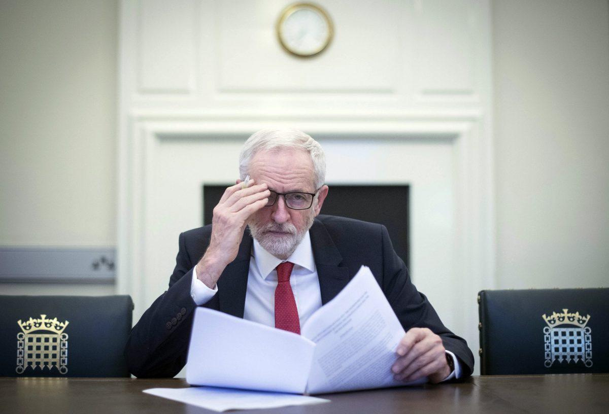 Britain's Labour leader Jeremy Corbyn poses for the media with the Political Declaration setting out the framework for the future UK-EU relationship, in his office in the Houses of Parliament in London, Tuesday, April 2, 2019. (Stefan Rousseau/Pool/AP)