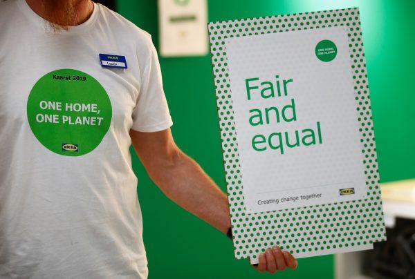 An employee of IKEA, holds a "fair and equal" placard during the start of the "One Home, One Planet" campaign of the world's biggest furniture group at a store in Kaarst near Duesseldorf, Germany, on April 3, 2019. (Wolfgang Rattay/Reuters)