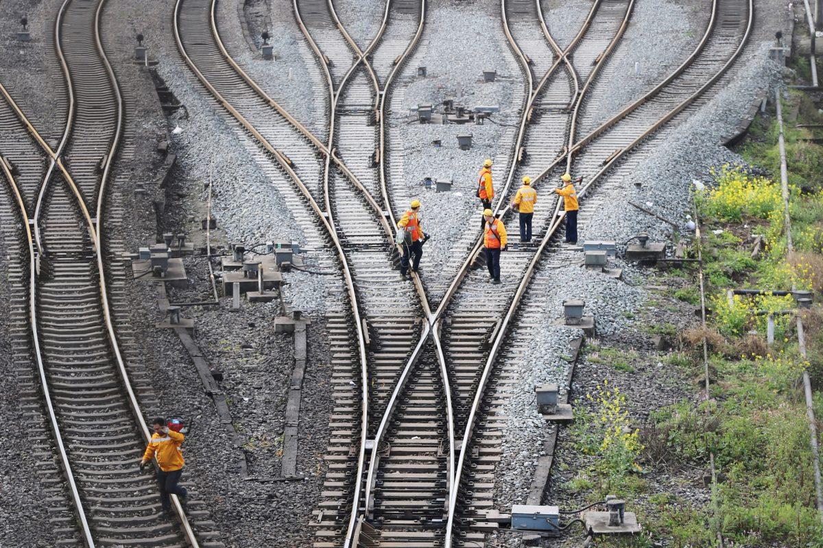 Workers inspect railway tracks, which serve as a part of the "One Belt, One Road" freight rail route linking Chongqing to Duisburg, Germany, at the Dazhou railway station in Sichuan Province, China on March 14, 2019. (Reuters)