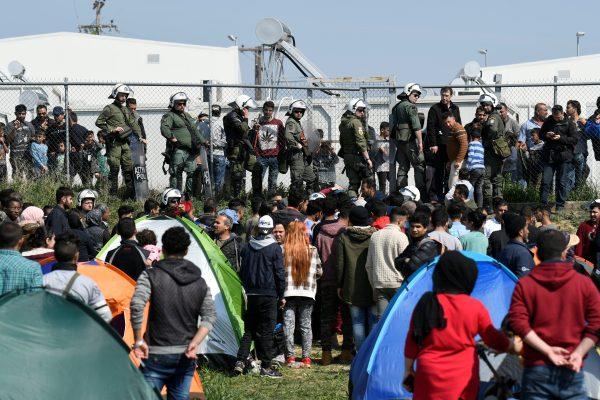 Migrants and refugees stand next to a camp in the town of Diavata in northern Greece, on April 4, 2019. (Alexandros Avramidis/Reuters)