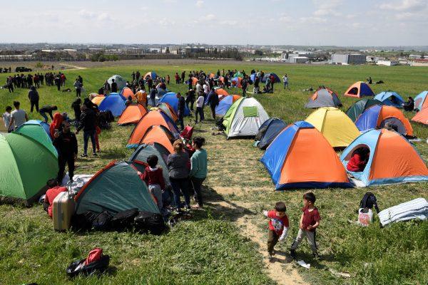 Migrants and refugees stand among tents in a field near the town of Diavata in northern Greece, on April 4, 2019. (Alexandros Avramidis/Reuters)