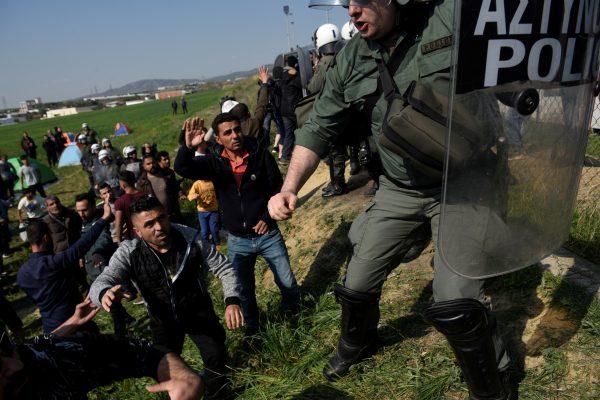 Migrants and refugees argue with riot police officers next to a camp in the town of Diavata in northen Greece, on April 4, 2019. (Alexandros Avramidis/Reuters)