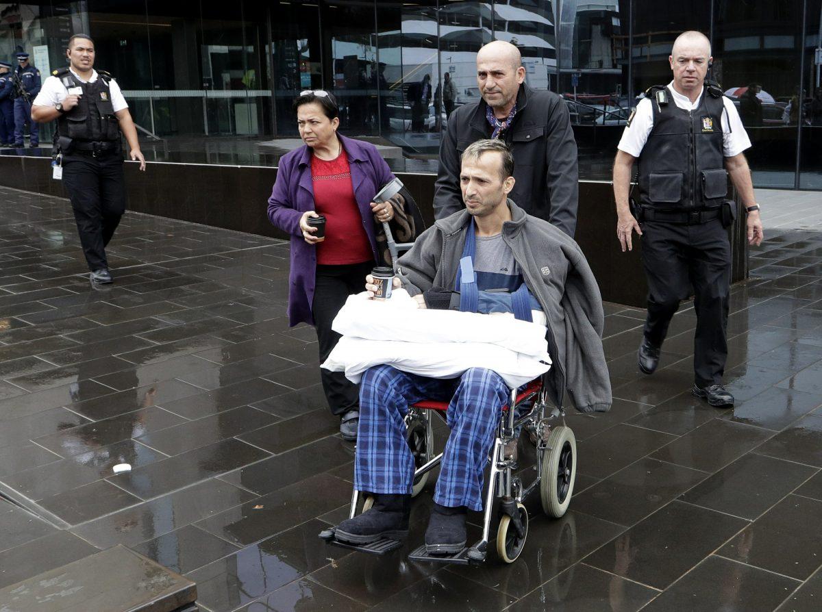 A man in a wheelchair is escorted from outside the High Court in Christchurch, New Zealand, on April 5, 2019. (Mark Baker/AP Photo)